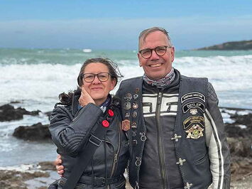 Zufriedenes Paar Motorradfahrer am Meer in der Toskana